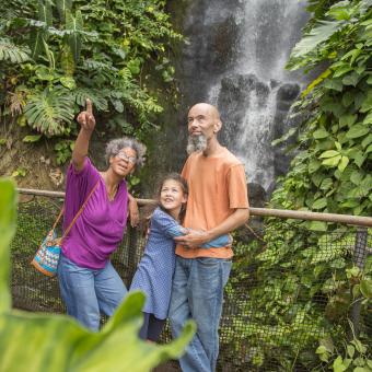 Family in Rainforest Biome standing by the waterfall